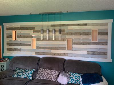 Mixed-wood wall divider with built-in lights behind a sofa