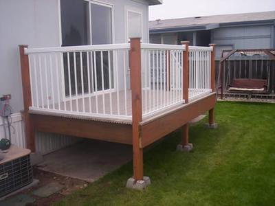 Raised deck with white railings outside a sliding door