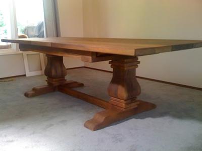 Trestle dining table with carved pedestal legs, finished