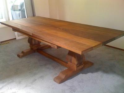 Trestle dining table seen from the end, showing the plank top